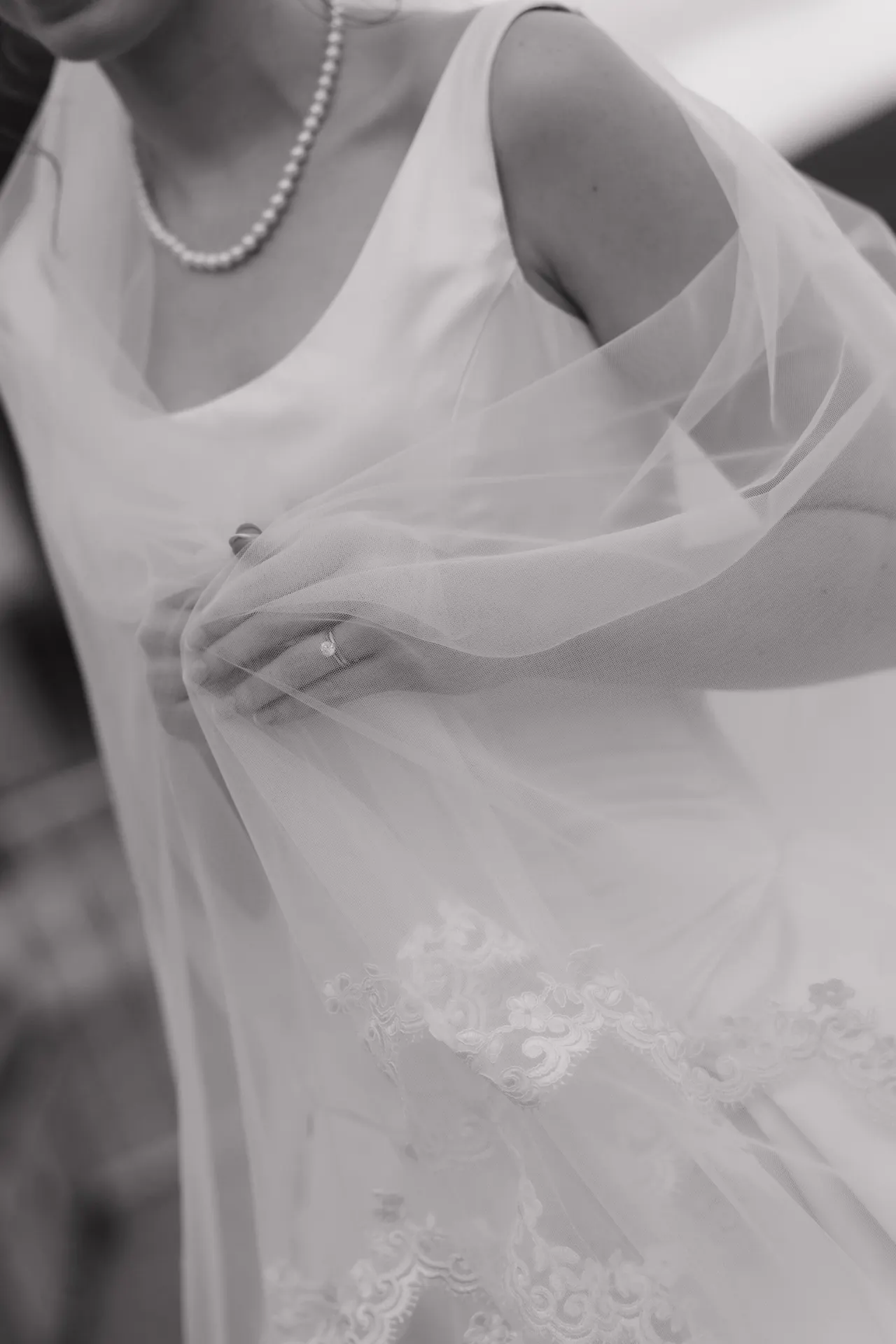 Soft detail of the bride's hands beneath her veil