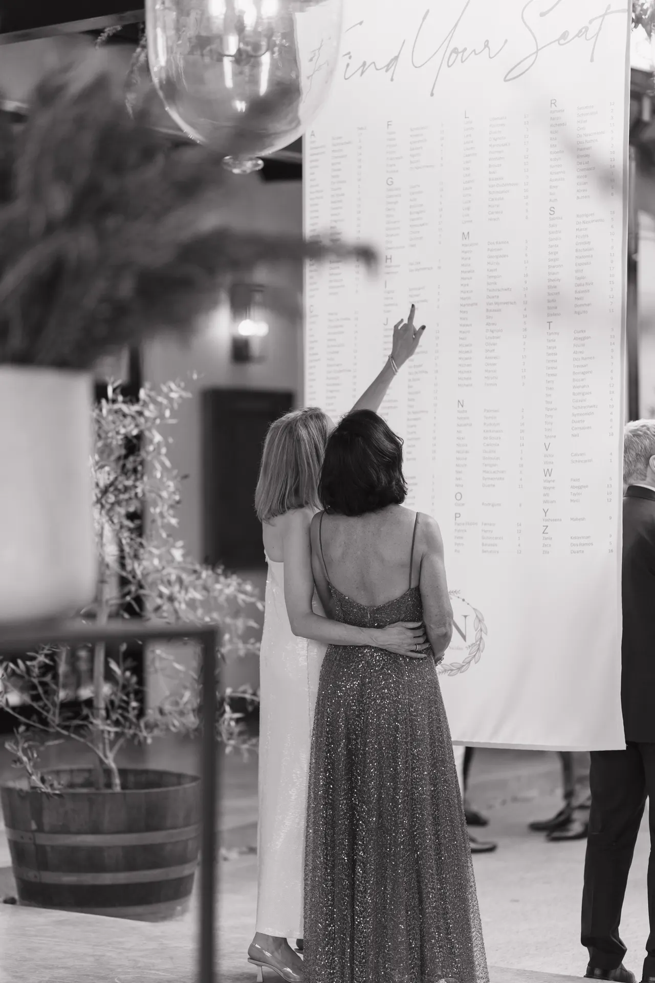 Black-and-white moment of guests finding their names on the seating chart