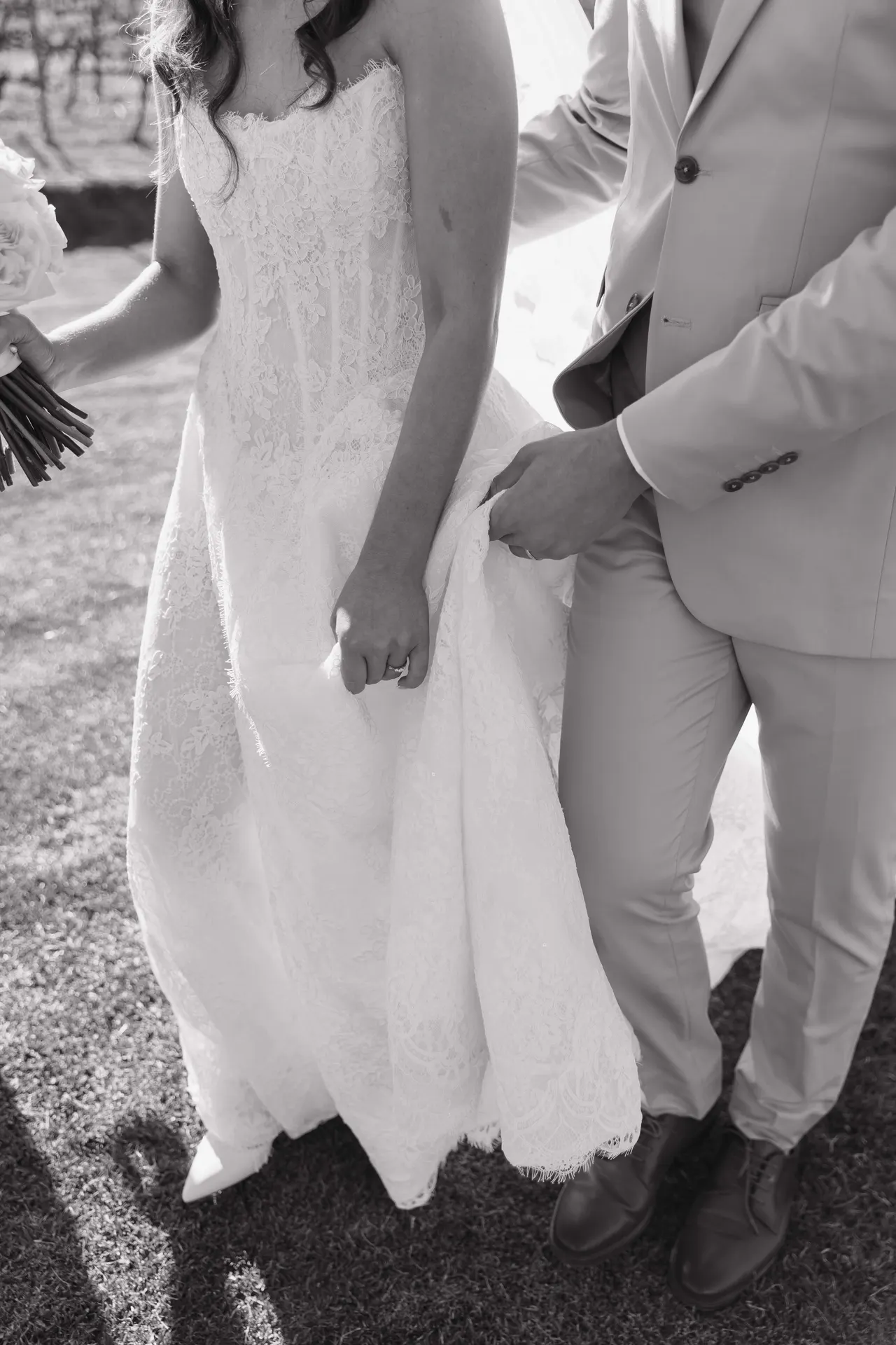 Black-and-white detail of the couple's hands clasped together